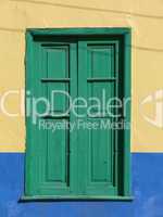 Grünes Fenster in gelber Fassade -.Green window with wooden blend