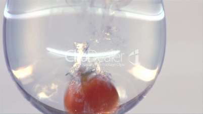 Tomate fällte in Wasser/-Glas, Zeitlupe