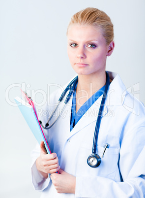 Serious doctor holding a clipboard