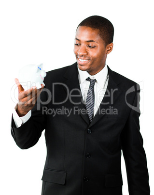 Young businessman looking at a piggy bank