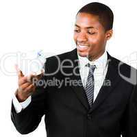 Close-up of an young businessman looking at a piggy bank