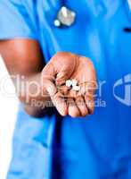 Close-up of an doctor holding pills and glass of water