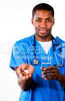 Handsome doctor in scrubs with pills and glass of water