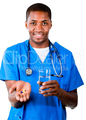 Smiling doctor in scrubs with pills and glass of water