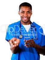 Friendly doctor in scrubs with pills and glass of water