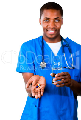 Portrait of an smiling doctor in scrubs with pills and glass of water
