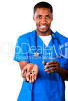 Portrait of an smiling doctor in scrubs with pills and glass of water