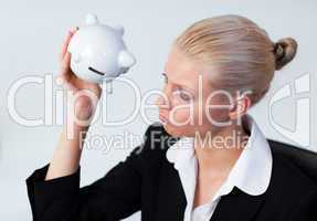 Sad Business woman looking into Piggy Bank