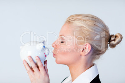 Woman kissing a piggy Bank