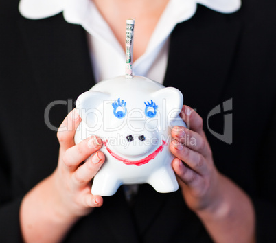 Woman Holding a piggy bank with dollars in it