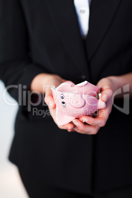 Business woman holding a broken piggy bank
