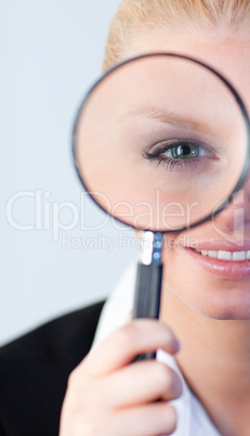 Smiling woman looking into a magniying glass