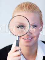 Smiling woman looking into a magniying glass