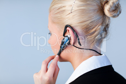Woman talking on a headset with focus on headset