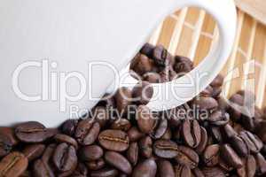 Coffee beans and cup on bamboo