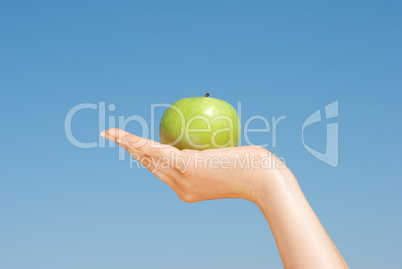Apple grapefruit in girl's hand over blue sky