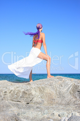 Beautiful girl meditating on the beach