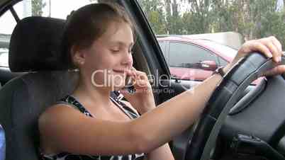 Young woman talking on mobile phone in car