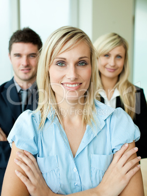 Business people headed by a woman with folded arms