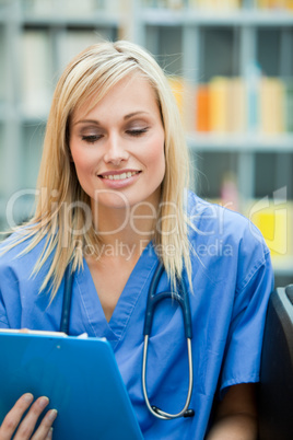 Young blond doctor reading a report