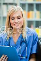 Young blond doctor reading a report