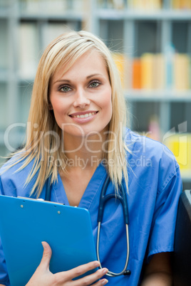 Young blond doctor at work smiling at the camera