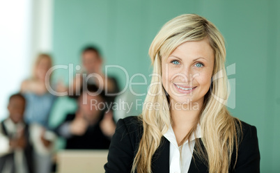 Businesswoman in front of her team in an office