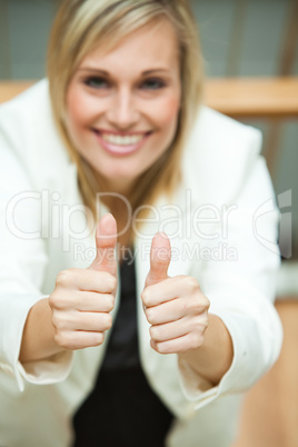 Businesswoman smiling at the camera with her thumbs up