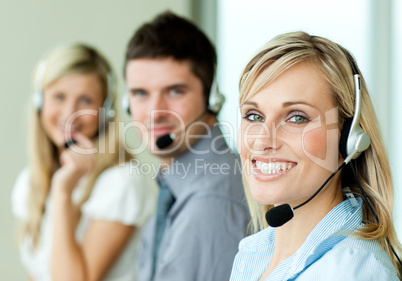 Young businesspeople smiling at the camera with headsets