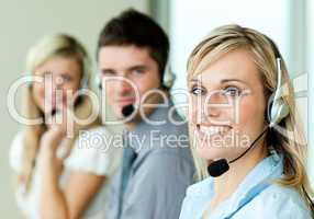 Young businesspeople smiling at the camera with headsets