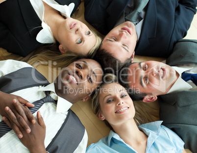 Closse-up of business people lying in a circle on the floor