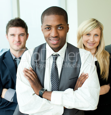 Afro-American businessman with folded arms with his colleagues