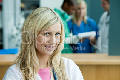 Blonde Ärztin - im Hintergrund Klinikpersonal