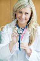 Blonde Ärztin hält Stethoskop in die Kamera