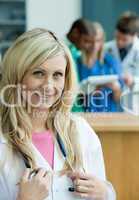 Blonde lächelnde Ärztin mit Stethoskop