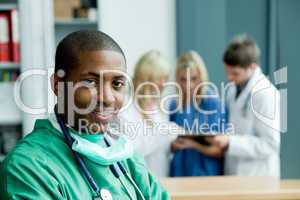 Arzt im grünen OP-Kittel mit Stethoskop