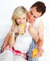 Couple drinking orange juice in bed