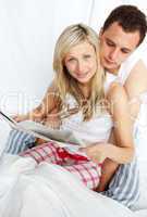 Couple reading a newspaper in bed