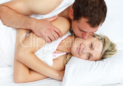 Boyfriend kissing his girlfriend in bed