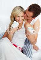 Couple in bed drinking coffee with affection