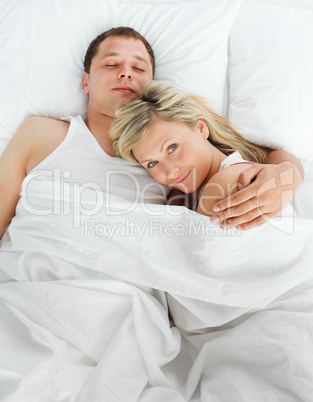 Woman lying in bed with a boy smiling at the camera