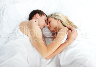 Boyfriend looking at her girlfriend sleeping in bed