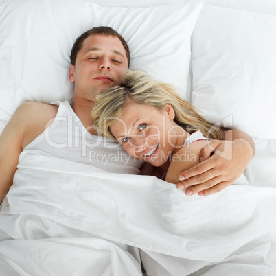 Woman lying in bed with a boy smiling at the camera