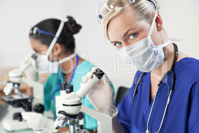 Female Scientific Research Team Using Microscopes in a Laborator