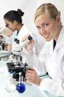 Female Scientific Research Team Using Microscopes in a Laborator