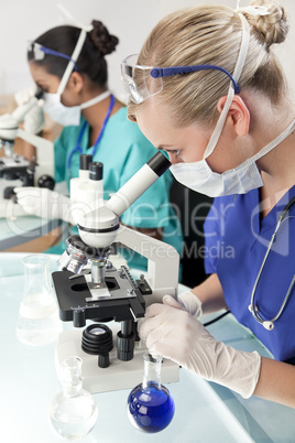 Female Scientific Research Team Using Microscopes in a Laborator