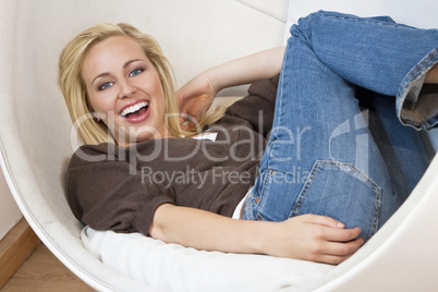 Beautiful Young Woman Laughing and Relaxing In A Bubble Chair