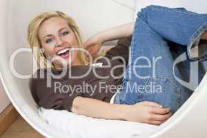 Beautiful Young Woman Laughing and Relaxing In A Bubble Chair