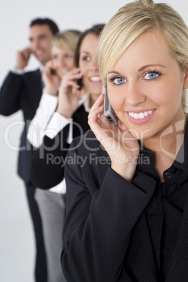 Beautiful Blond Woman On Cell Phone With Team Behind Her