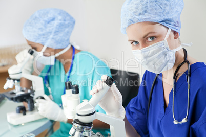 Female Scientists or Doctors Using Microscopes in a Laboratory